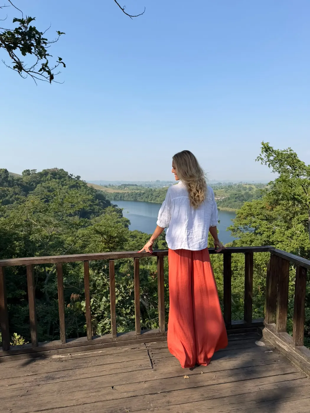 Voyageuse contemplant un lac entouré de forêt en Ouganda